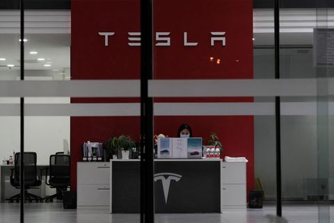 Eine Mitarbeiterin an ihrem Arbeitsplatz in einem Tesla-Showroom