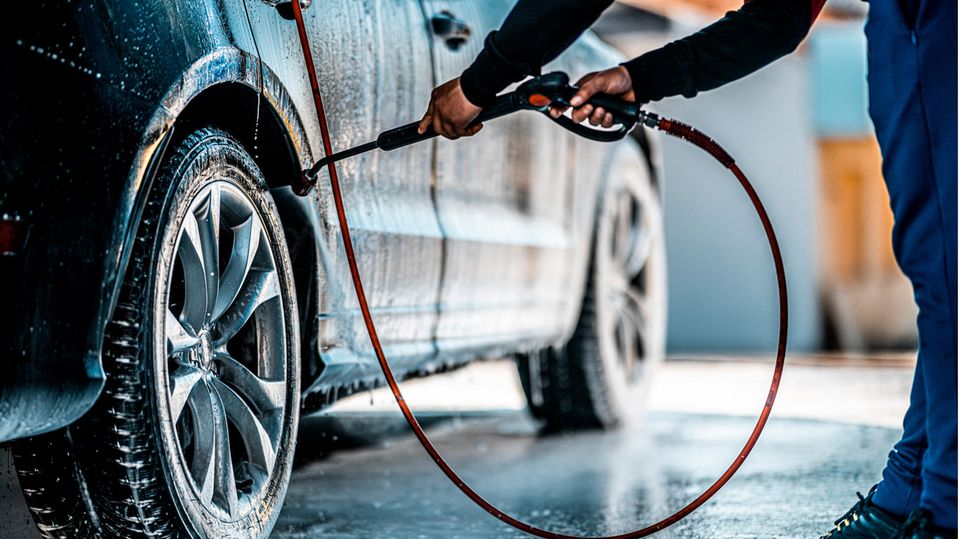 Eine Person wäscht ein Auto