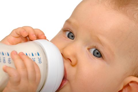 Ein Baby hält ein Fläschchen