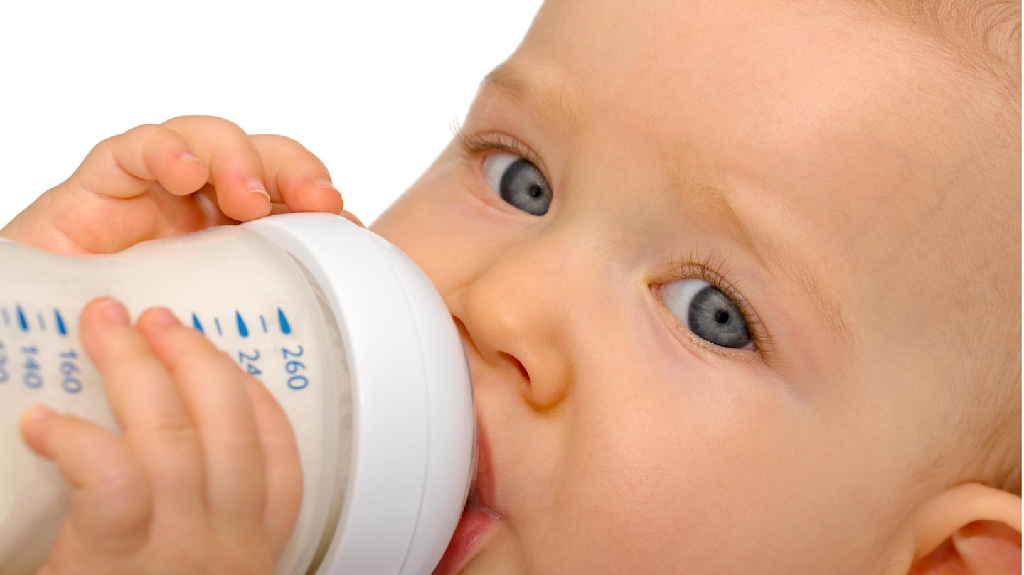 Ein Baby hält ein Fläschchen