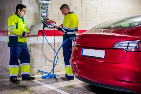 Zwei Mechaniker arbeiten an einem Elektroauto