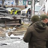 Ein verkohltes Metallteil, das wie das Leitwerk einer Rakete aussieht, liegt zwischen Trümmern auf einem schmalen Grünstreifen