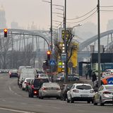 Autos stehen vor einer Tankstelle in einer langen Schlange auf der rechten Spur einer mehrspurigen Straße