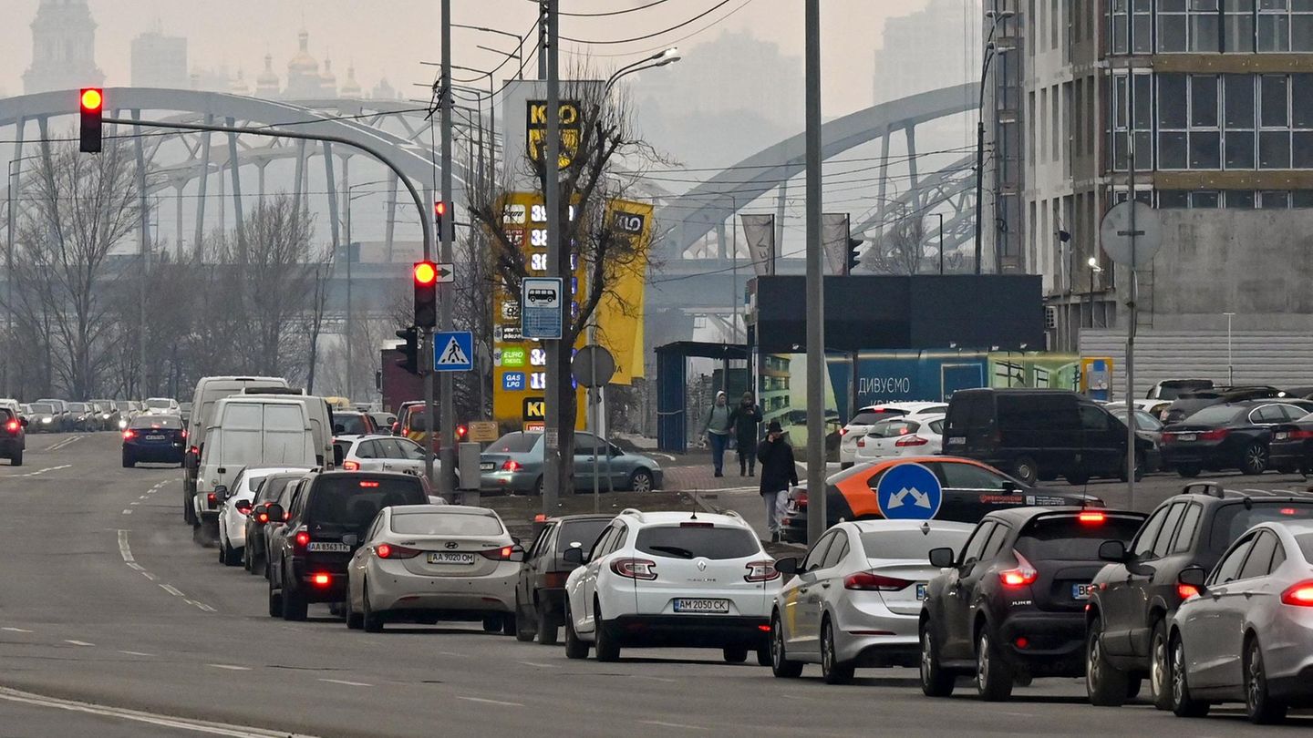 Autos stehen vor einer Tankstelle in einer langen Schlange auf der rechten Spur einer mehrspurigen Straße