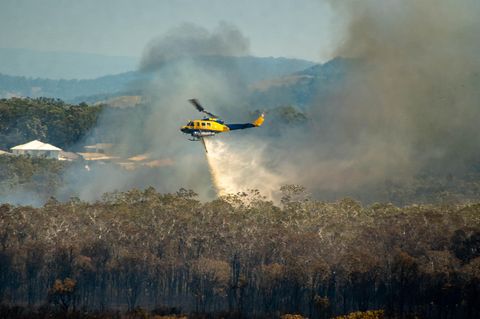 Ein Hubschrauber löscht ein Feuer im Wald von Australien