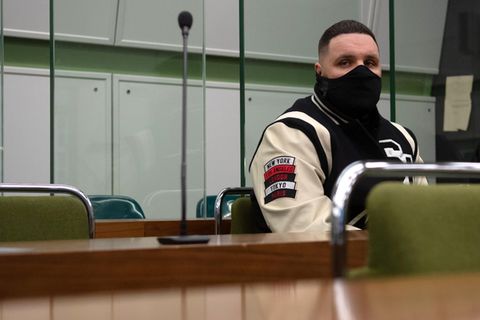 Rapper Fler sitzt in einem Gerichtssaal.