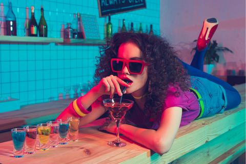 Klut-Drinks der 80er: Eine Frau liegt auf dem Tresen und trinkt einen Cocktail.