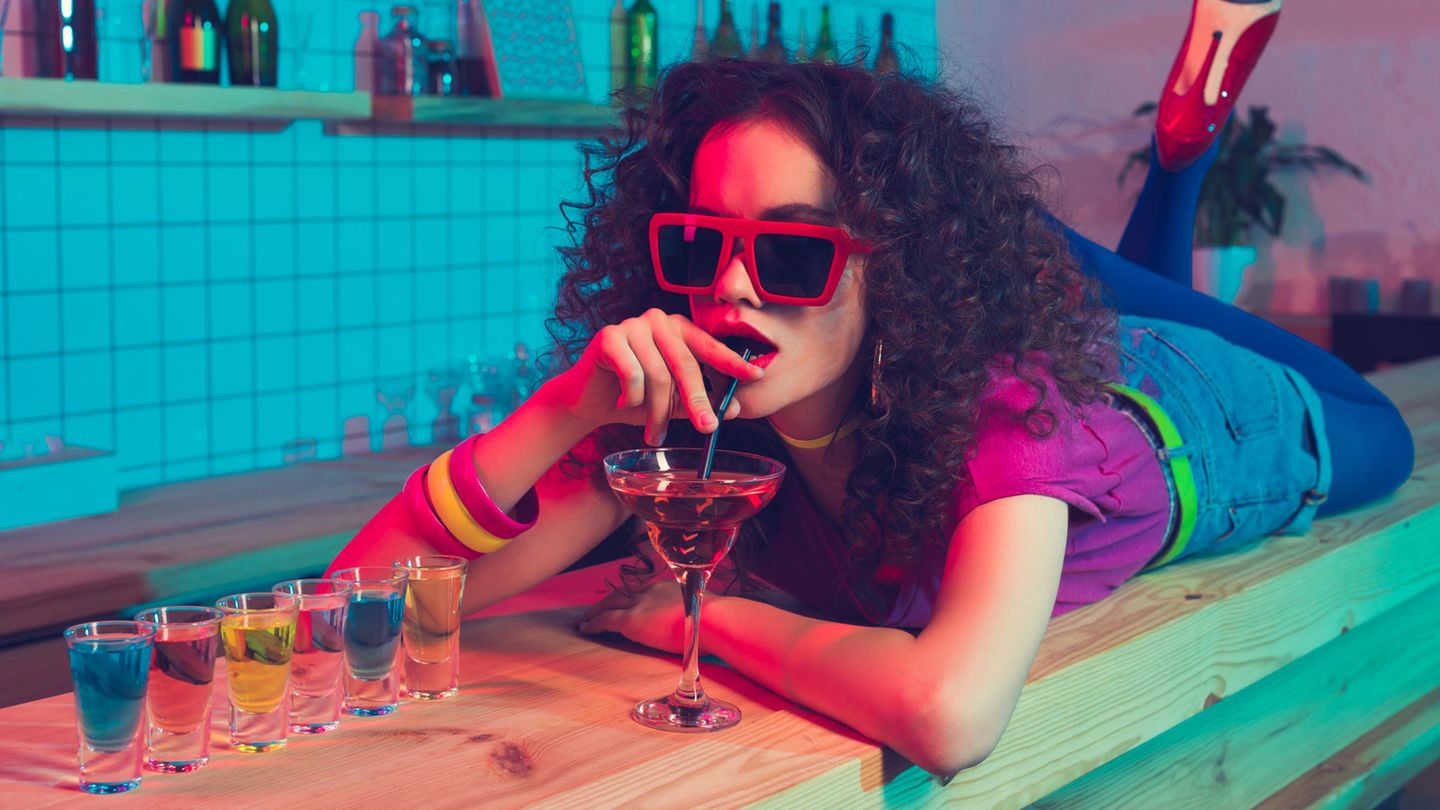 Klut-Drinks der 80er: Eine Frau liegt auf dem Tresen und trinkt einen Cocktail.