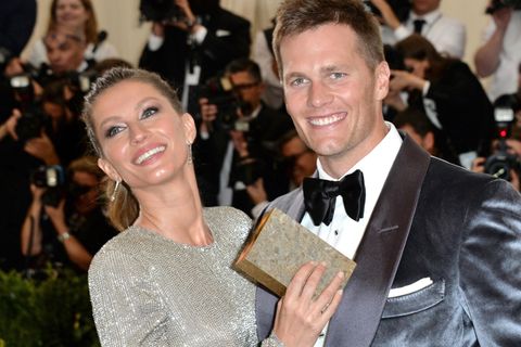 Tom Brady lacht mit seiner Frau Gisele Bündchen auf dem roten Teppich in die Kamera