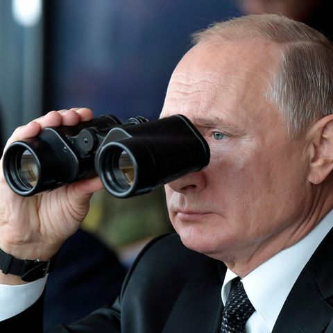 Durch ein Fernglas beobachtet Wladimir Putin, Präsident von Russland, Militärübungen