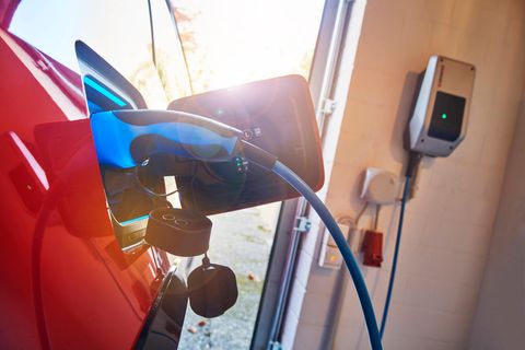 Ein Elektroauto lädt an einer Wallbox in einer Garage