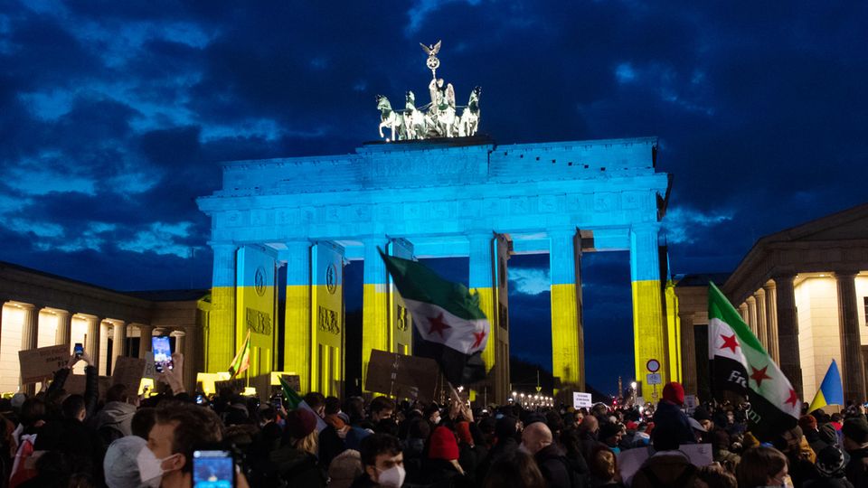 Das Brandenburger Tor wird am Abend bei einer Solidaritäts-Demonstration für die Ukraine in den Farben der Ukraine angeleuchtet