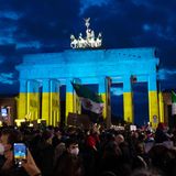 Das Brandenburger Tor wird am Abend bei einer Solidaritäts-Demonstration für die Ukraine in den Farben der Ukraine angeleuchtet