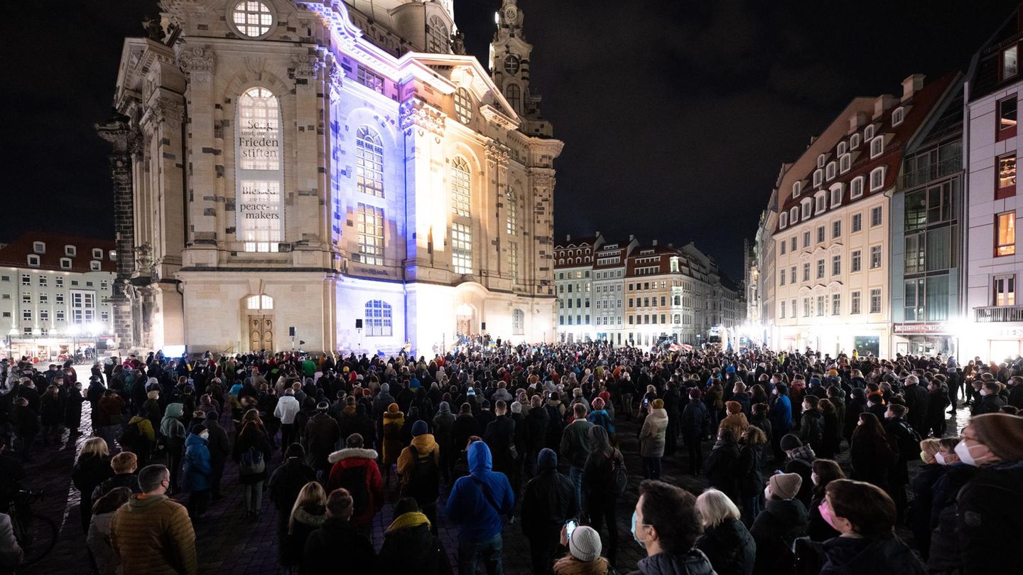 Teilnehmer stehen während einer Kundgebung auf dem Neumarkt in Dresden