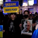Eine Demonstrantin hält ein Schild mit einer Fotomontage von Adolf Hitler und dem russischen Präsidenten Wladimir Putin hoch
