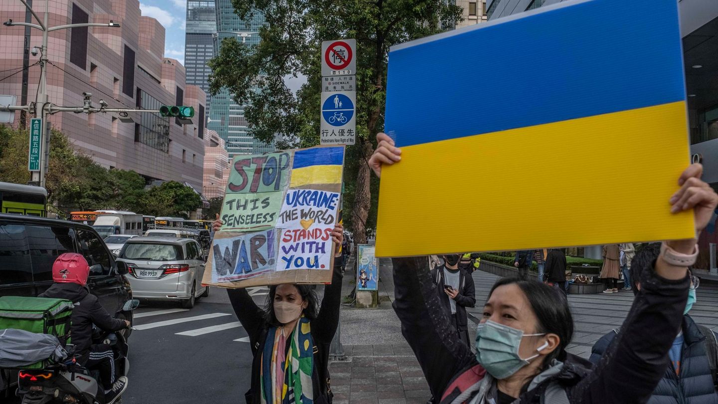 Demonstrierende zeigen Plakate vor dem Repräsentanzbüro der Koordinierungskommission Moskau-Taipeh