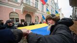 Mit einer großen ukrainischen Flagge demonstrieren Menschen vor der russischen Botschaft