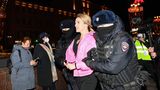 Vermummte Polizeikräfte führen eine Demonstrantin ab