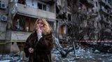 Eine Ukrainerin vor einem zerstörten Wohnhaus in der Hauptstadt.