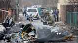 Ein Soldat der ukrainischen Armee inspiziert Fragmente eines abgestürzten Flugzeugs. Es ist nicht erkennbar, ob es sich um einen russischen oder ukrainischen Flieger handelt oder wer es zum Absturz gebracht hat.