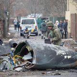 Ein Soldat der ukrainischen Armee inspiziert Fragmente eines abgestürzten Flugzeugs. Es ist nicht erkennbar, ob es sich um einen russischen oder ukrainischen Flieger handelt oder wer es zum Absturz gebracht hat.