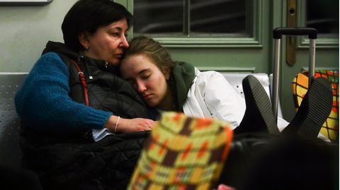 Zwei Frauen versuchen, auf einer Bank zu schlafen