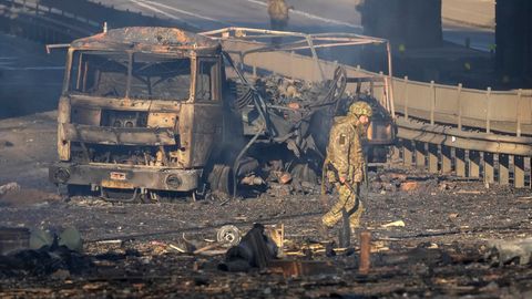 Ukraine, Kiew: Ein ukrainischer Soldat geht an den Trümmern eines ausgebrannten Militärlastwagens vorbei