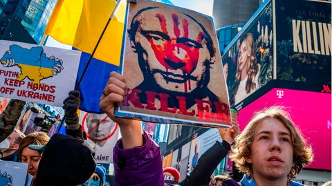 In der US-Metropole New York gingen Menschen auf die Straße, um gegen die Invasion in der Ukraine zu protestieren. Die Wut vieler Demonstranten richtete sich vor allem gegen den russischen Präsidenten Wladimir Putin, der hier auf einem Schild als "Killer" bezeichnet und mit einer blutigen Hand auf seinem Gesicht abgebildet wird.