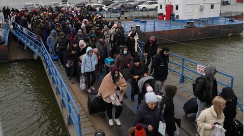 Menschen verlassen ein Boot an der Grenze von Isaccea im Rumänien, um dem Krieg in der Ukraine zu entfliehe