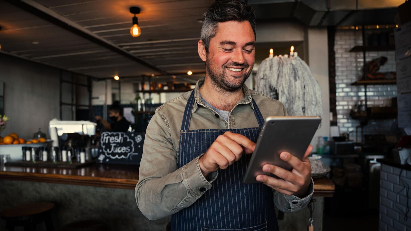Ein Kellner hält ein 8-Zoll-Tablet in der Hand.