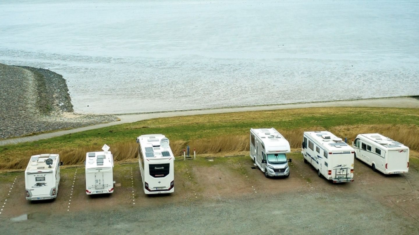 Wohnmobile stehen auf einem Parkplatz in Neuharlingersiel an der Nordseeküste