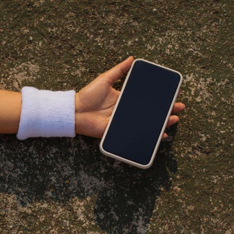 Ein Smartphone in der Hand einer am Boden liegenden Frau