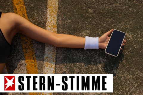 Ein Smartphone in der Hand einer am Boden liegenden Frau