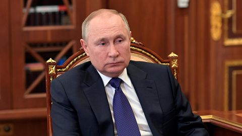 Wladimir Putin sitzt auf einem Stuhl und schaut nüchtern aus dem Bild