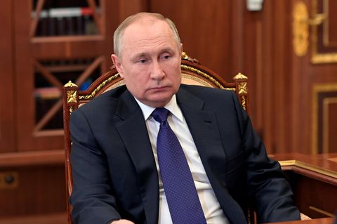 Wladimir Putin sitzt auf einem Stuhl und schaut nüchtern aus dem Bild