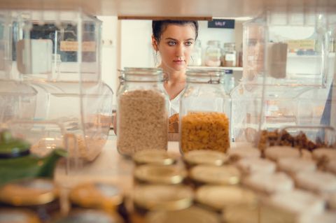 Eine Frau steht vor ihrem Vorratsschrank
