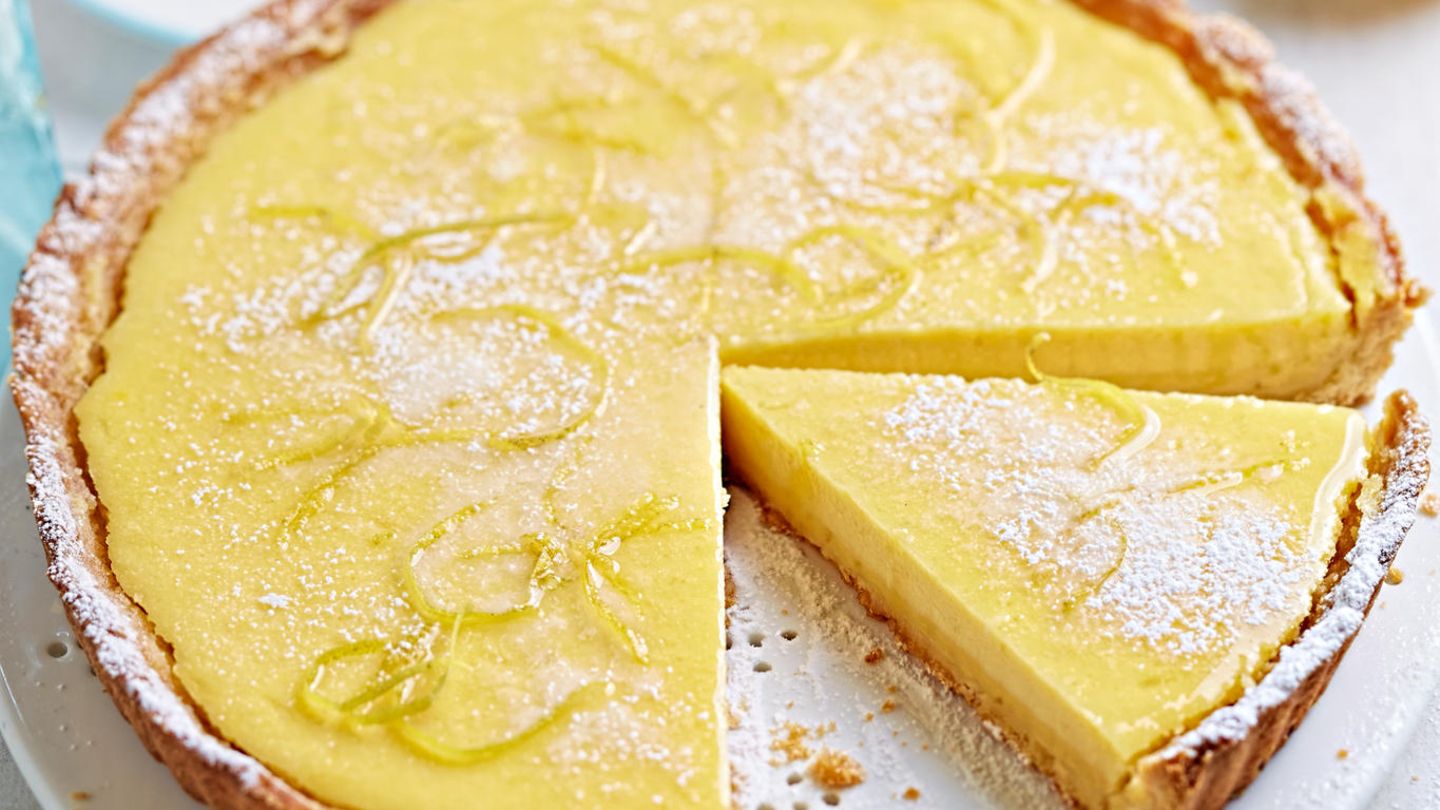 Aus einer Zitronentarte ist ein Kuchenstück herausgeschnitten