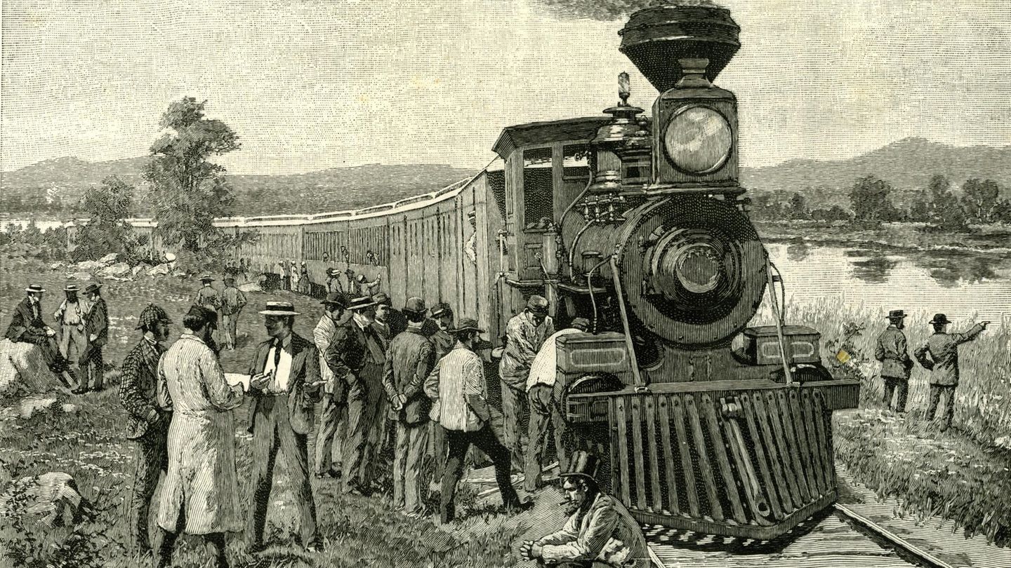 Männer warten vor einer Lokomotive, die nicht mehr fährt. Sie sind auf dem Welt in den Yellowstone Nationalpark. Bild von 1891
