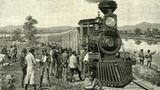 Männer warten vor einer Lokomotive, die nicht mehr fährt. Sie sind auf dem Welt in den Yellowstone Nationalpark. Bild von 1891