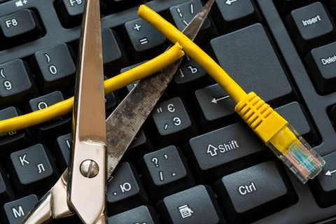 Eine Schere durchtrennt ein Ethernet-Kabel