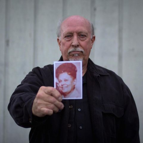 Ein Mann hält ein Foto in die Kamera