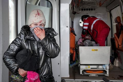 Krieg in der Ukraine: Eine Mutter steht in Mariopol vor einem Rettungswagen, in dem Sanitäter um das Leben ihrer Tochter kämpfen