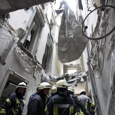 Feuerwehrmänner untersuchen die Regionalverwaltung von Charkiw nach einem Bombenangriff