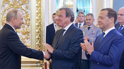 Wladimir Putin (l) schüttelt Gerhard Schröder (M) die Hand