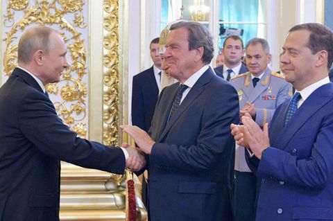 Wladimir Putin (l) schüttelt Gerhard Schröder (M) die Hand