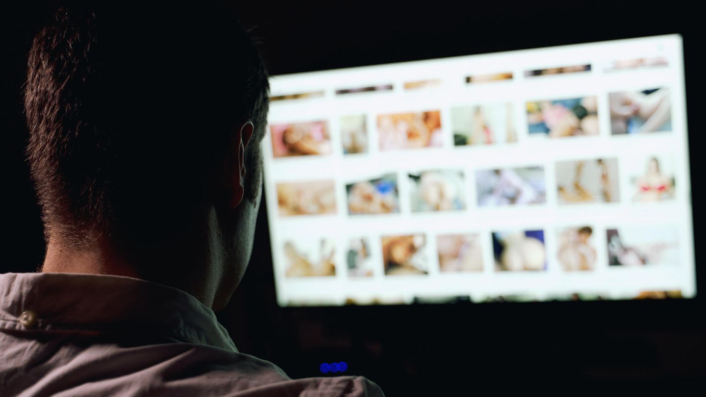 Mann sitzt vor Sex-Webseiten im Internet