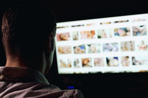 Mann sitzt vor Sex-Webseiten im Internet