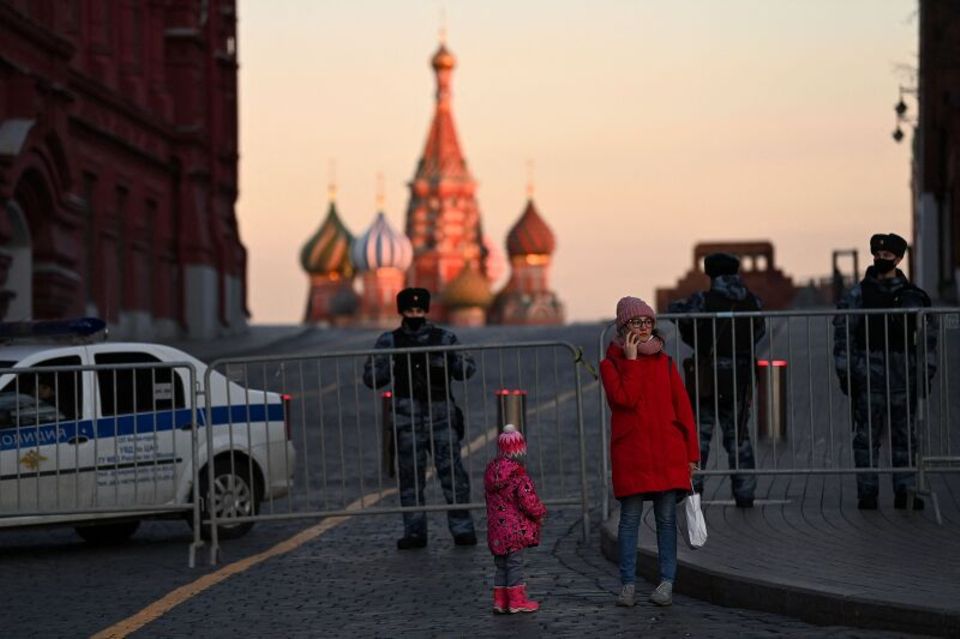 Los policías bloquean el camino de una madre y su hijo.  Por temor a las protestas justo frente a los muros del Kremlin, Vladimir Putin cerró durante días la Plaza Roja, la plaza central de la capital rusa, donde la vida suele cobrar vida. 