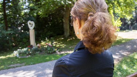 Eine Frau trauert am Ohlsdorfer Friedhof in Hamburg an einem Gedenkplatz für nicht beerdigte Kinder um ihr verstorbenes Kind