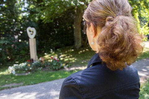 Eine Frau trauert am Ohlsdorfer Friedhof in Hamburg an einem Gedenkplatz für nicht beerdigte Kinder um ihr verstorbenes Kind